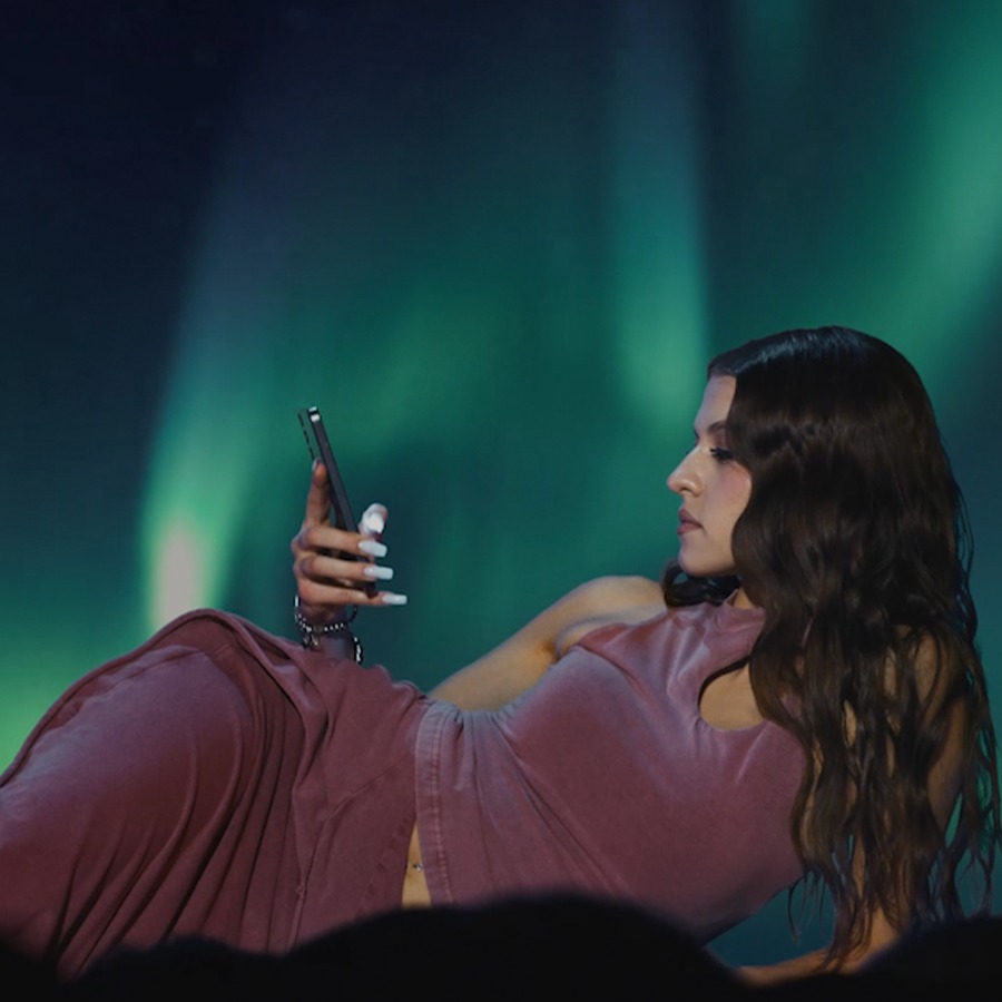 View from the audience of woman using her phone