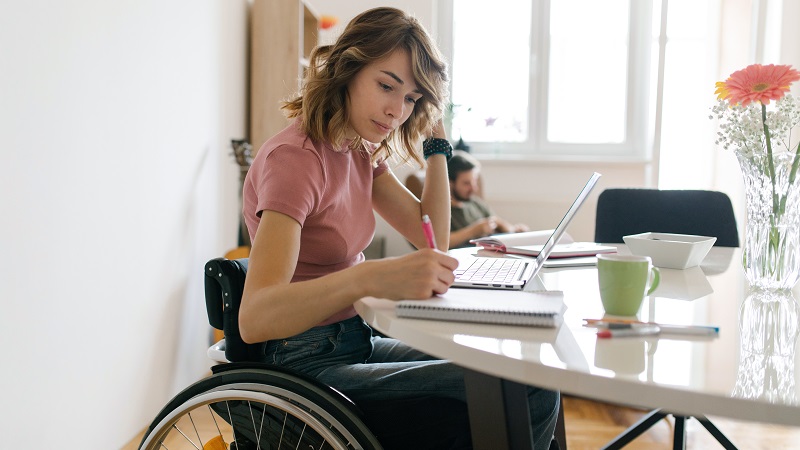 Młoda kobieta z na wózku inwalidzkim czyta blog Visa