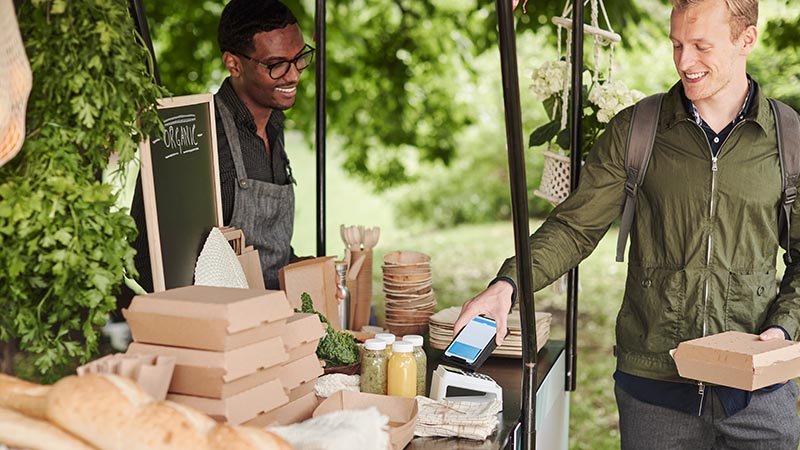 man making mobile payment at stall